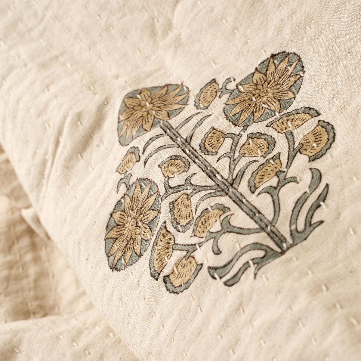Couverture Kantha beige avec broderie et motif floral ocre en gros plan