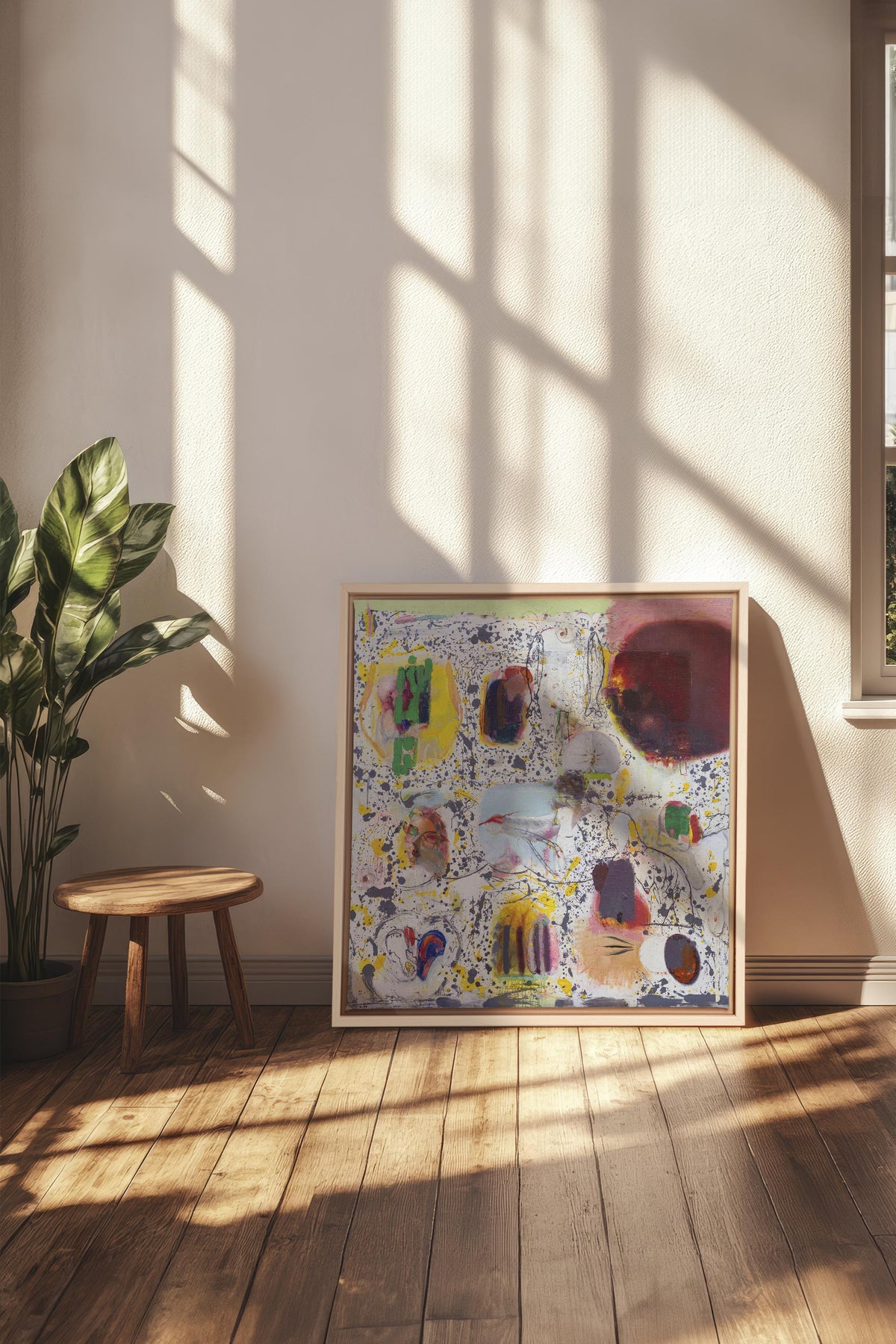 Œuvre sur toile étirée abstraite en cadre bois, motifs colorés sur sol en parquet.