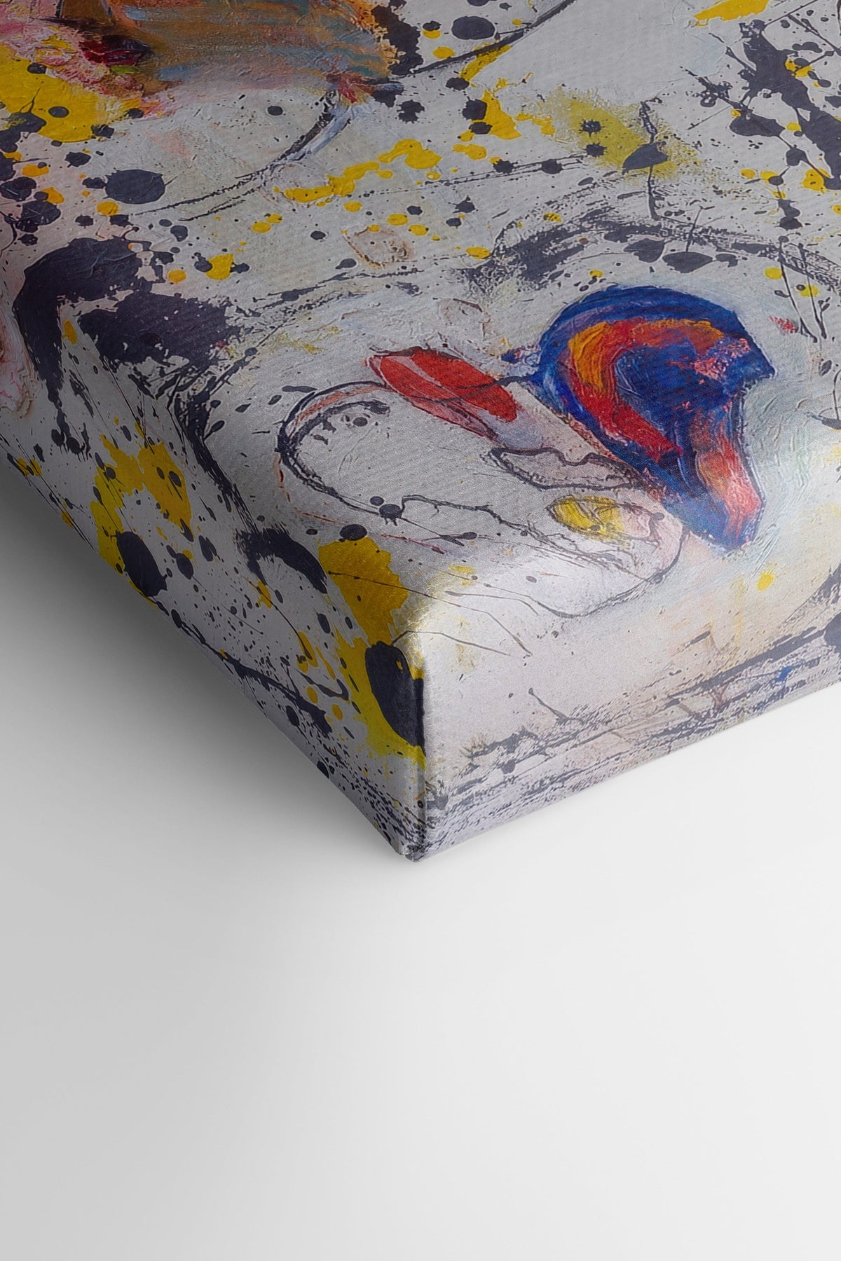 Toile étirée abstraite vue en biais, empâtements et éclaboussures multicolores.