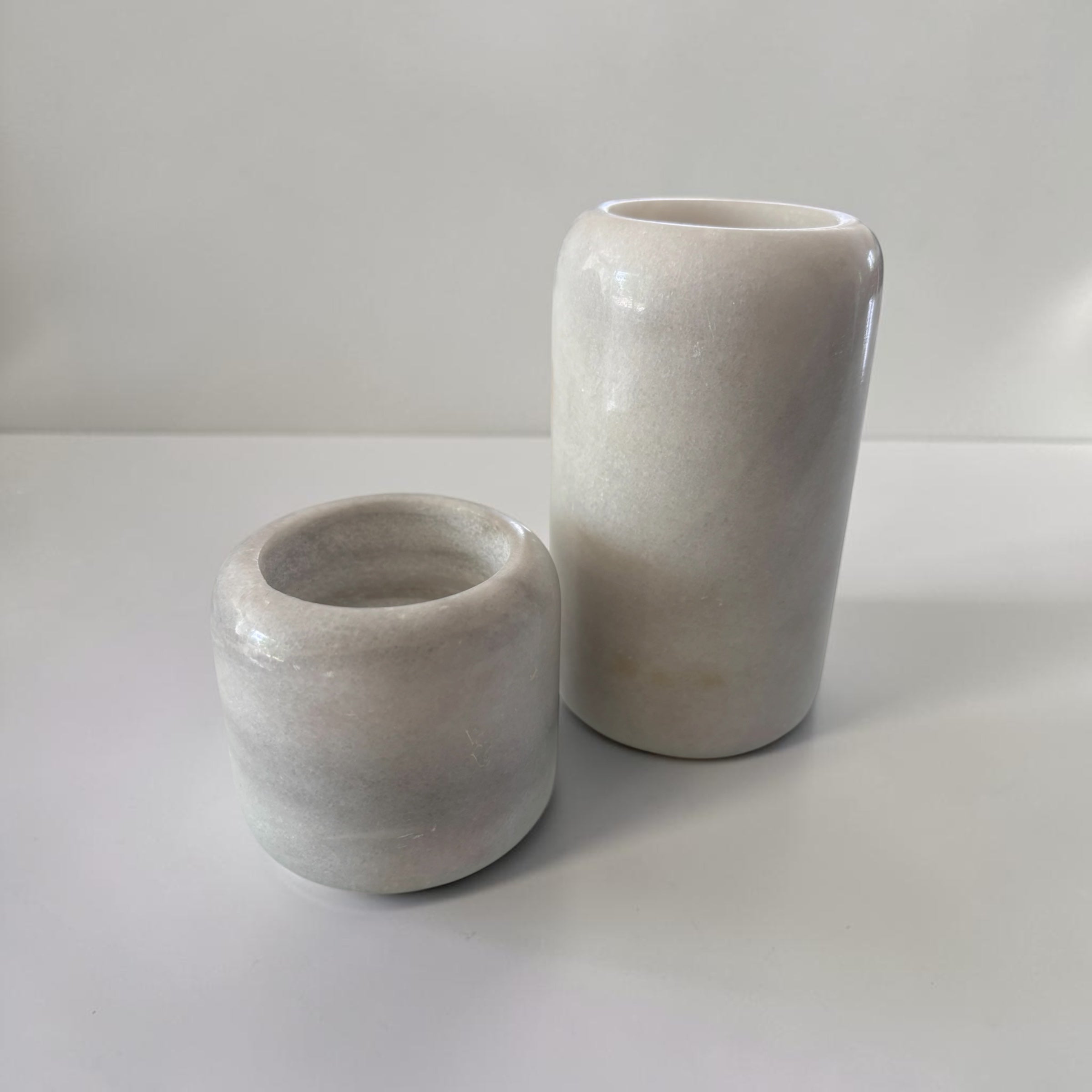 Ensemble de bougeoirs en marbre blanc et gris de deux tailles