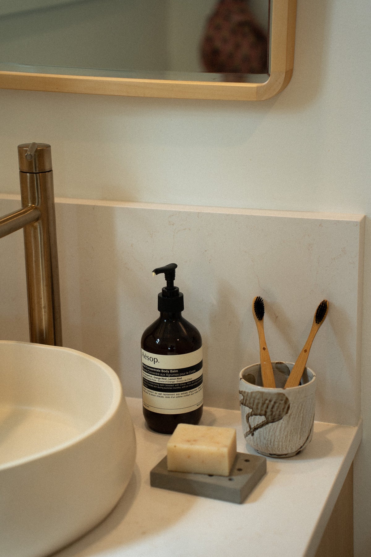 Porte-savon en béton gris sur plan de lavabo, avec barre de savon