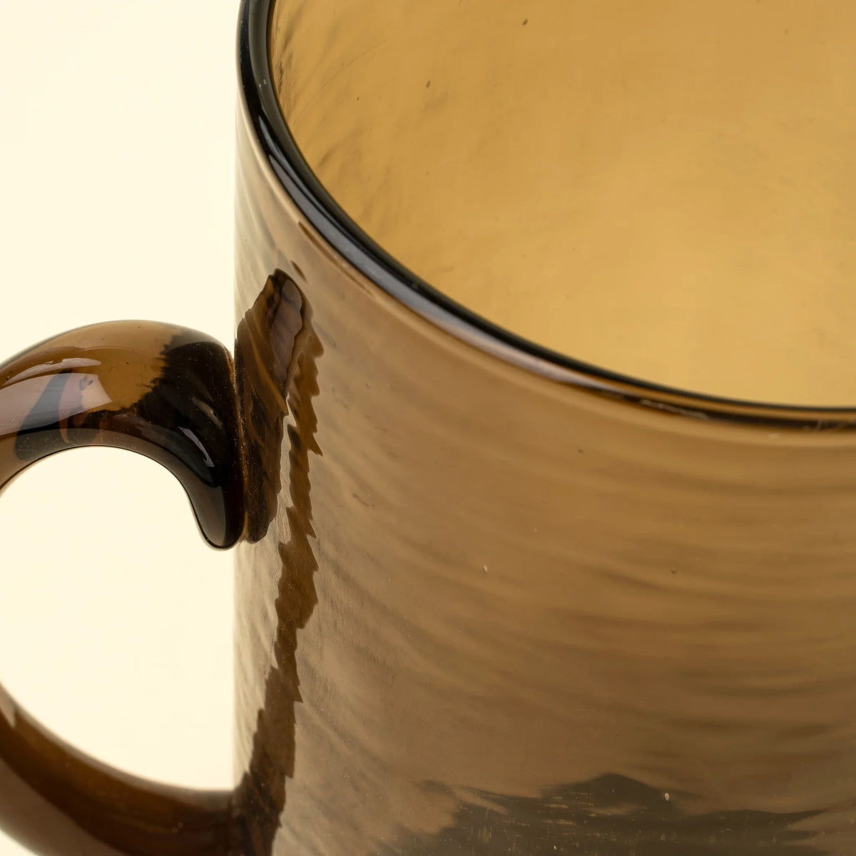 Pichet Montenegro en verre recyclé, avec silhouette cylindrique et teinte brun terreux.