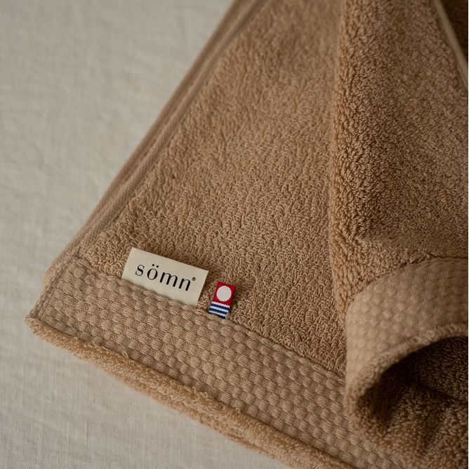 Serviette de bain Asobi en coton, beige brun, texture éponge et bord texturé