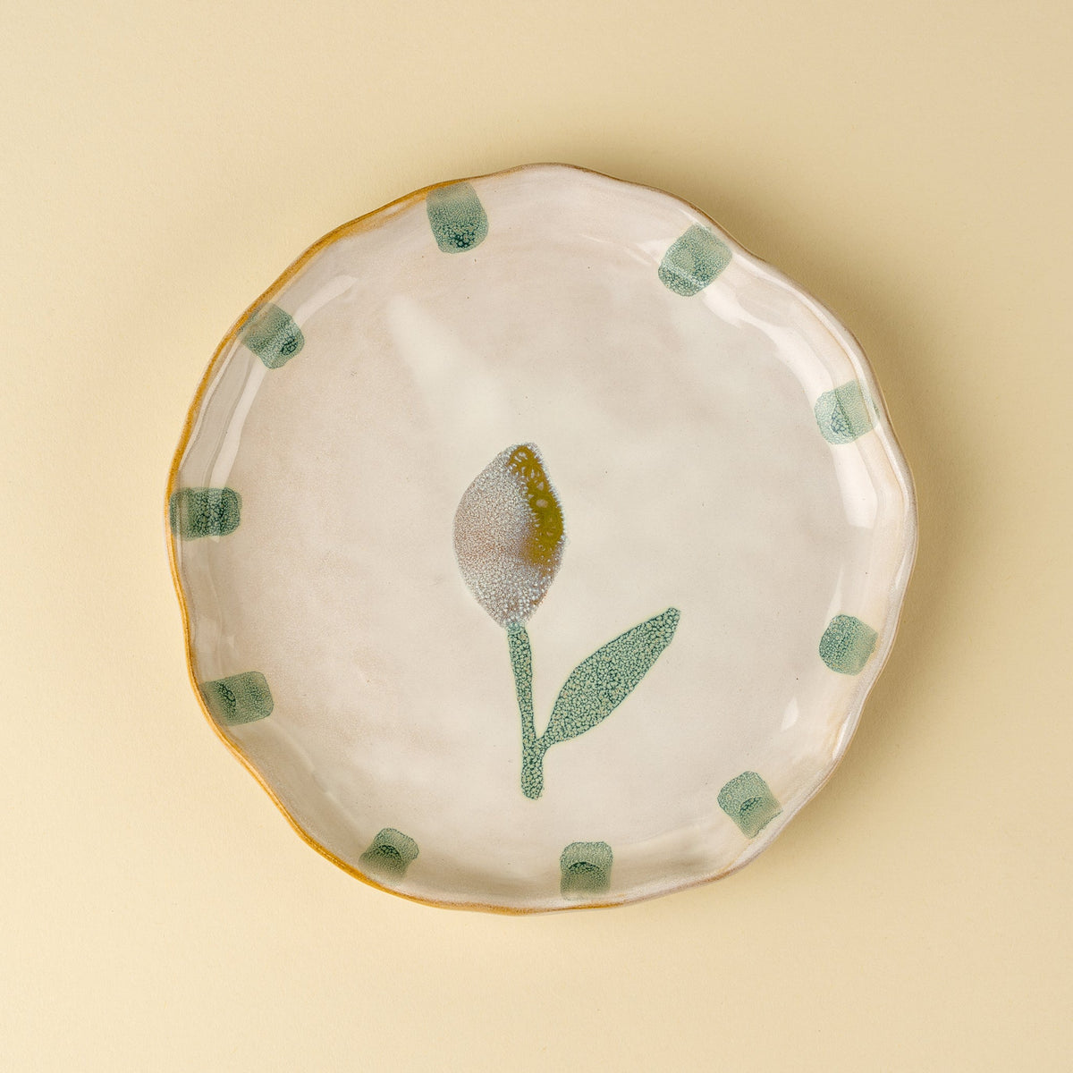 Assiette en céramique artisanale avec motif citron jaune et vert, bord festonné