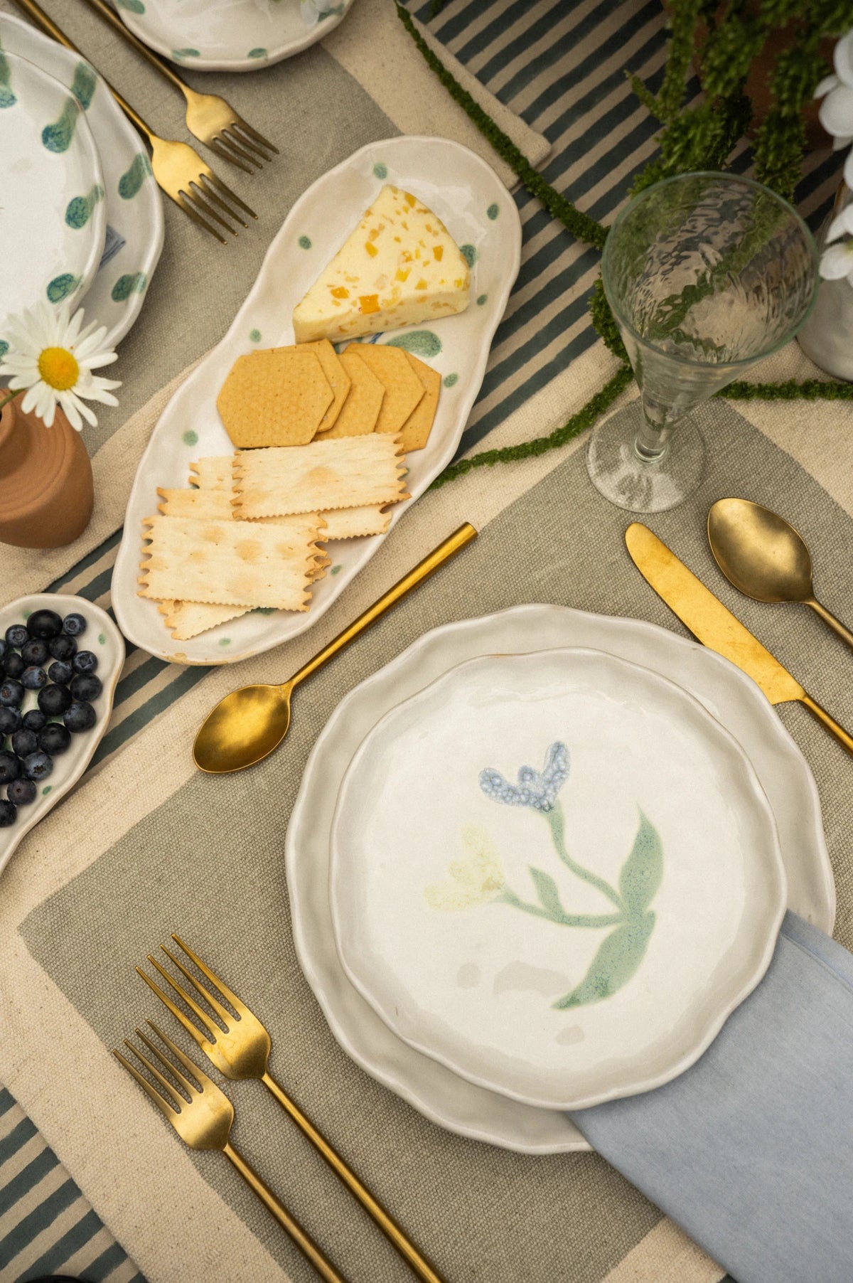 Assiette en céramique blanche à bords ondulés, motif floral bleu-vert