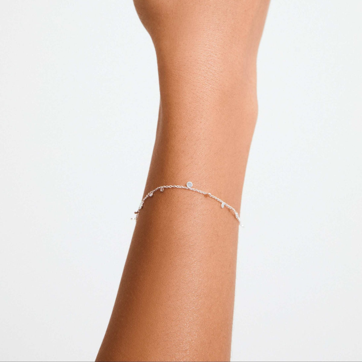 Bracelet fin plaqué argent à petites pièces, porté autour du poignet