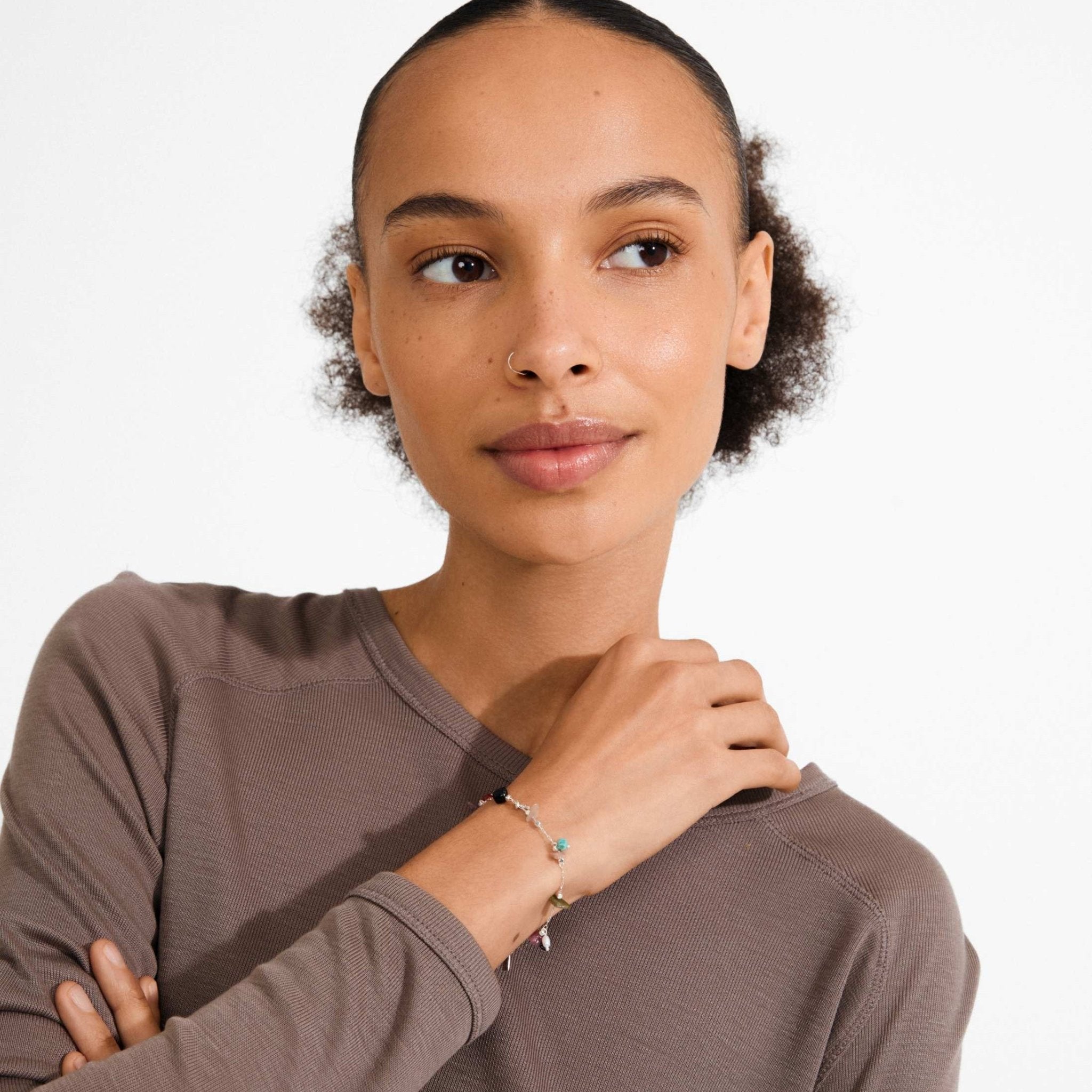 Bracelet à pierres colorées, porté par une femme, vue sur le poignet
