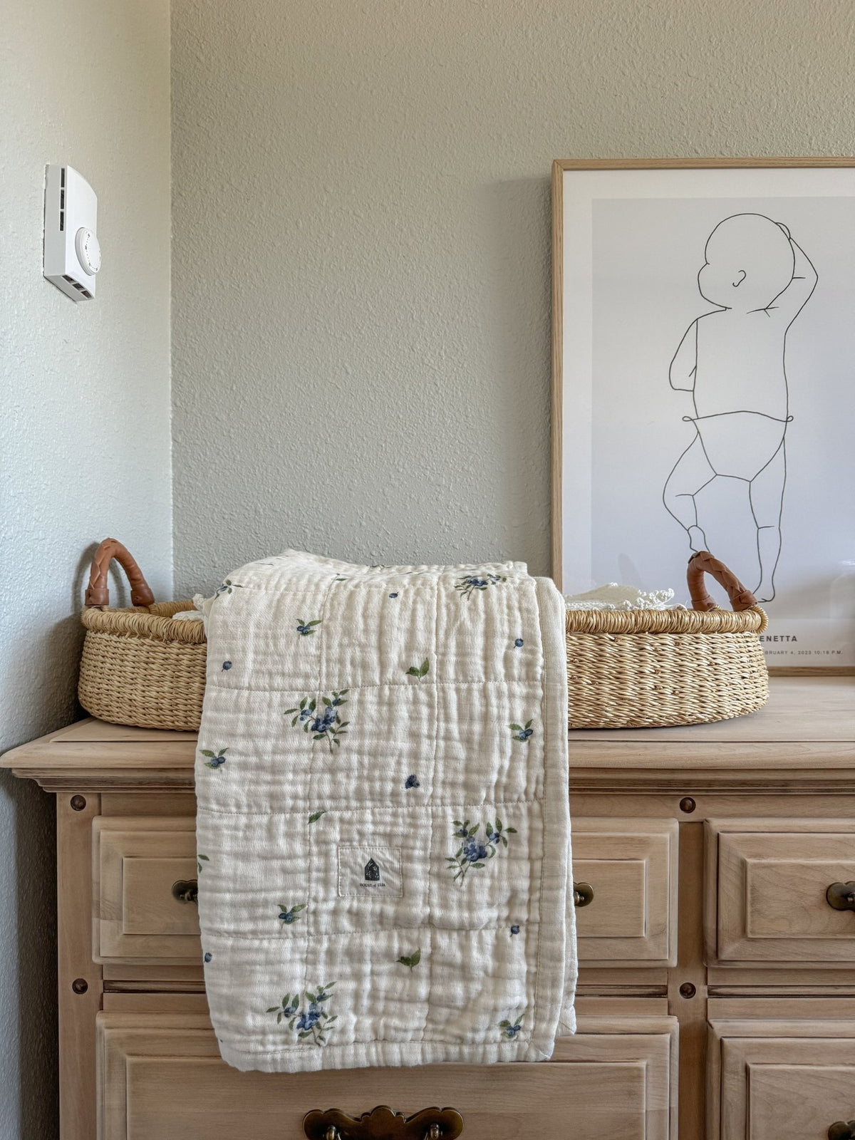 Couverture bébé en mousseline 4 couches blanche à motifs fleuris bleu et vert, pliée