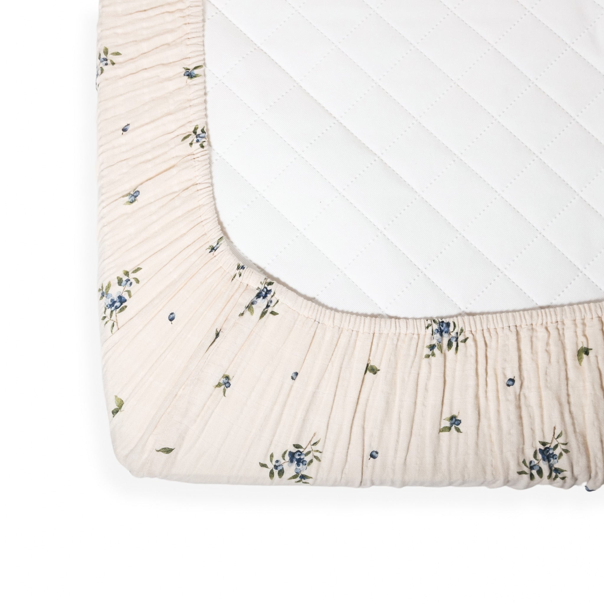 Drap contour en mousseline écrue avec bord élastiqué, motif fleuri bleu et vert