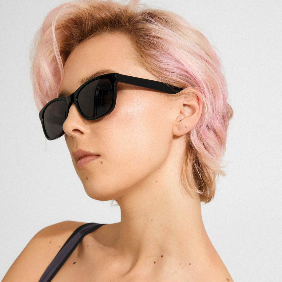 Lunettes de soleil à monture noire, verres fumés, vue de profil