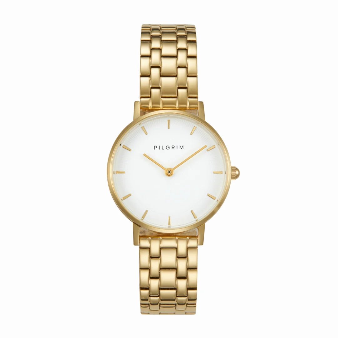 Montre TRAVELER CIDER Pilgrim dorée avec cadran blanc minimaliste et bracelet réglable en acier inoxydable.