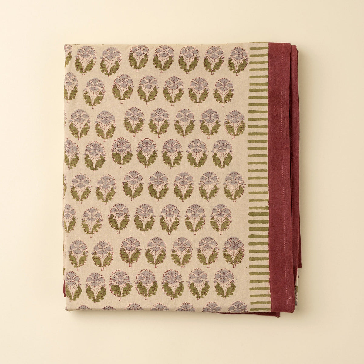 Nappe en coton crème, carré replié, feuillages lilas et verts, bord bordeaux et rayures
