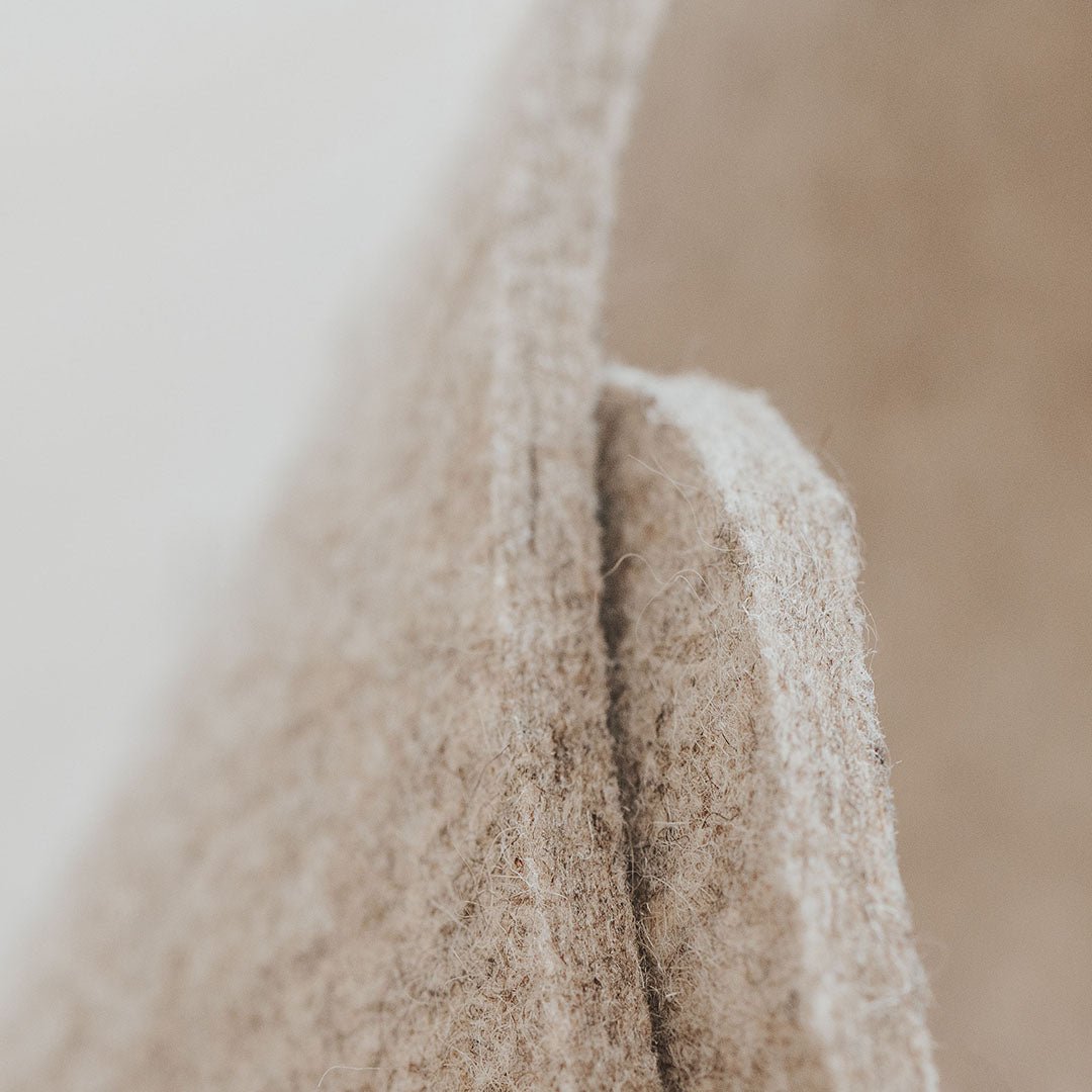 Panier en feutre de laine beige, gros plan sur couture latérale verticale
