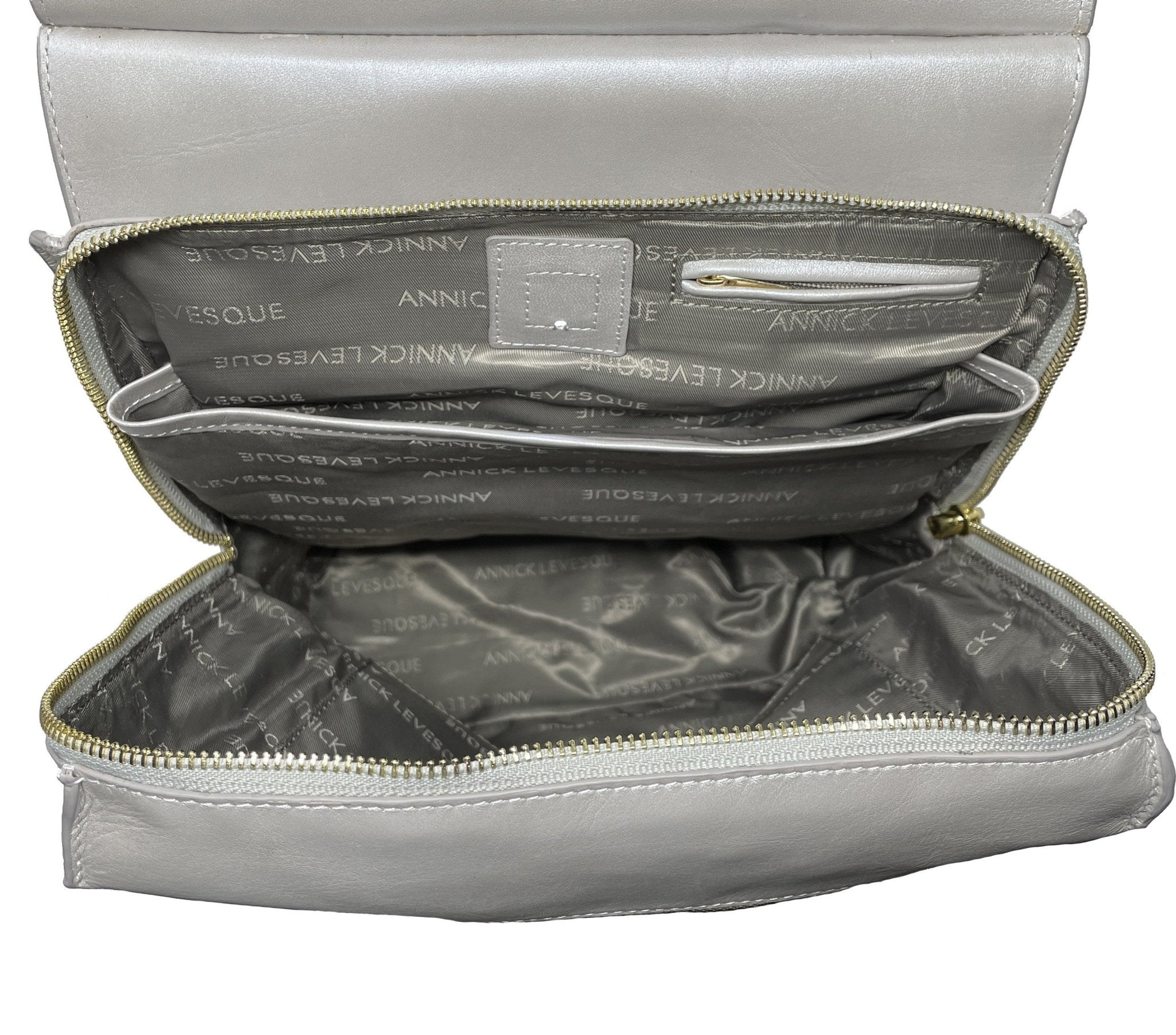 Sac à dos en cuir gris ouvert, doublure avec poche interne, fermeture zippée