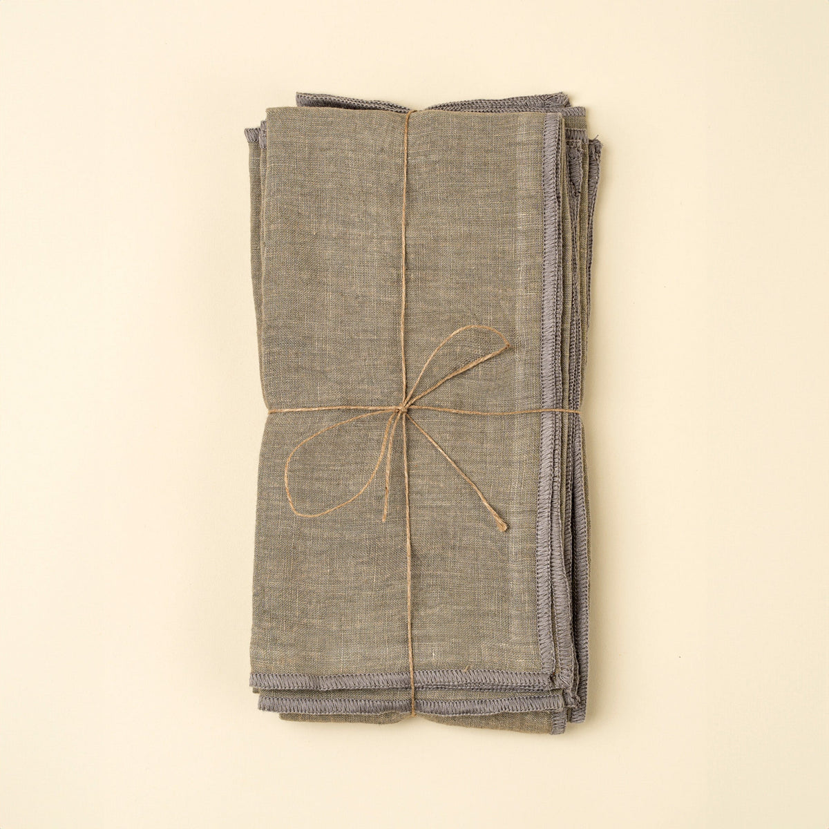 Lot de 4 serviettes en lin lavé gris, pliées et attachées par un ruban