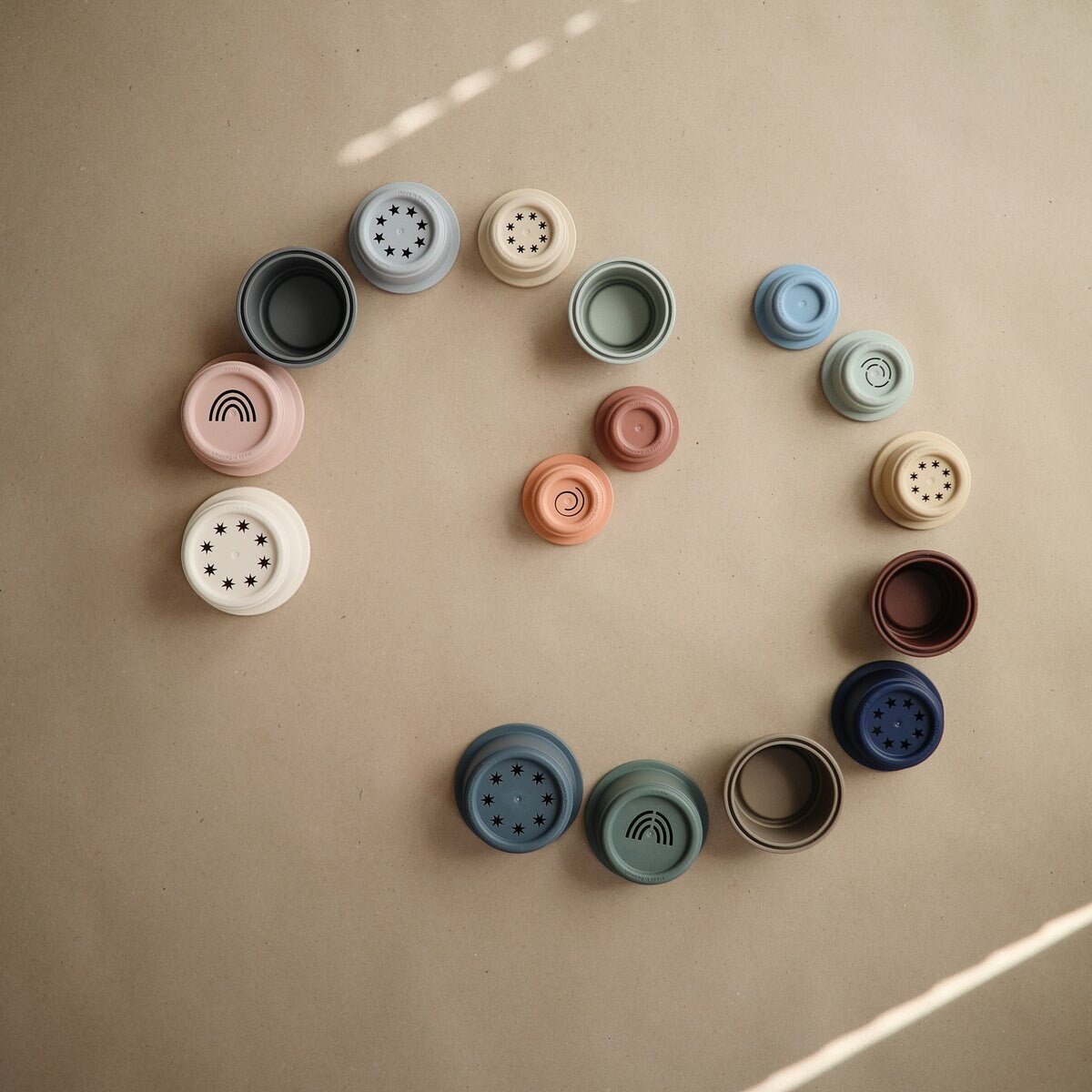 Jeu de gobelets empilables bébé avec couvercles perforés, couleurs variées.