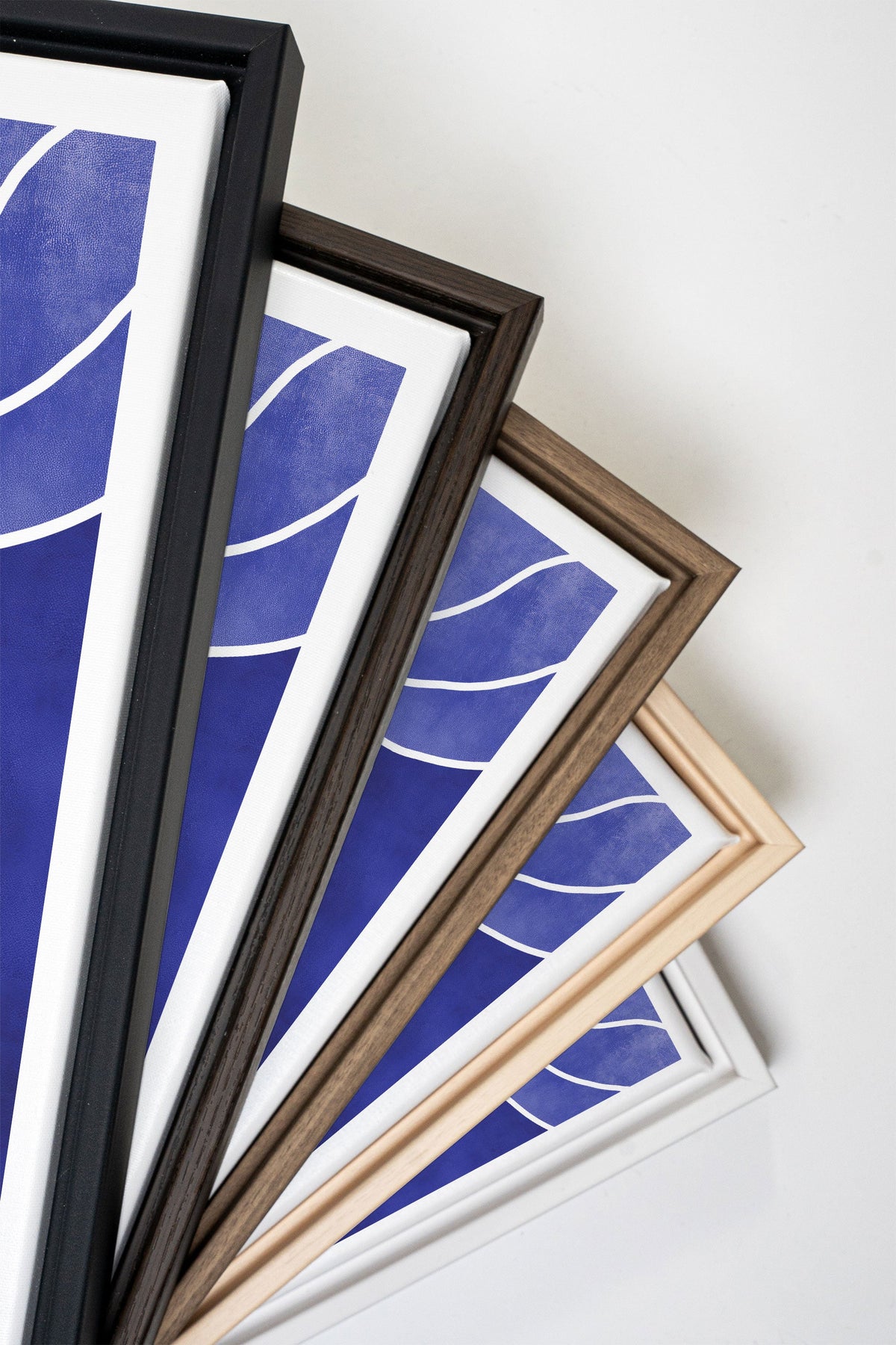 Série de tableaux indigo avec lignes blanches, cadres bois, vue en pile