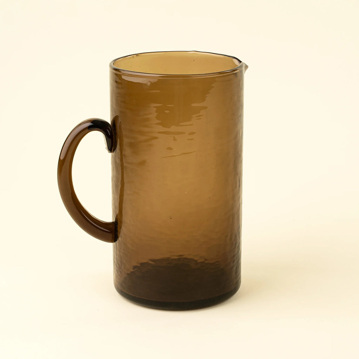 Pichet Montenegro en verre recyclé, avec silhouette cylindrique et teinte brun terreux.