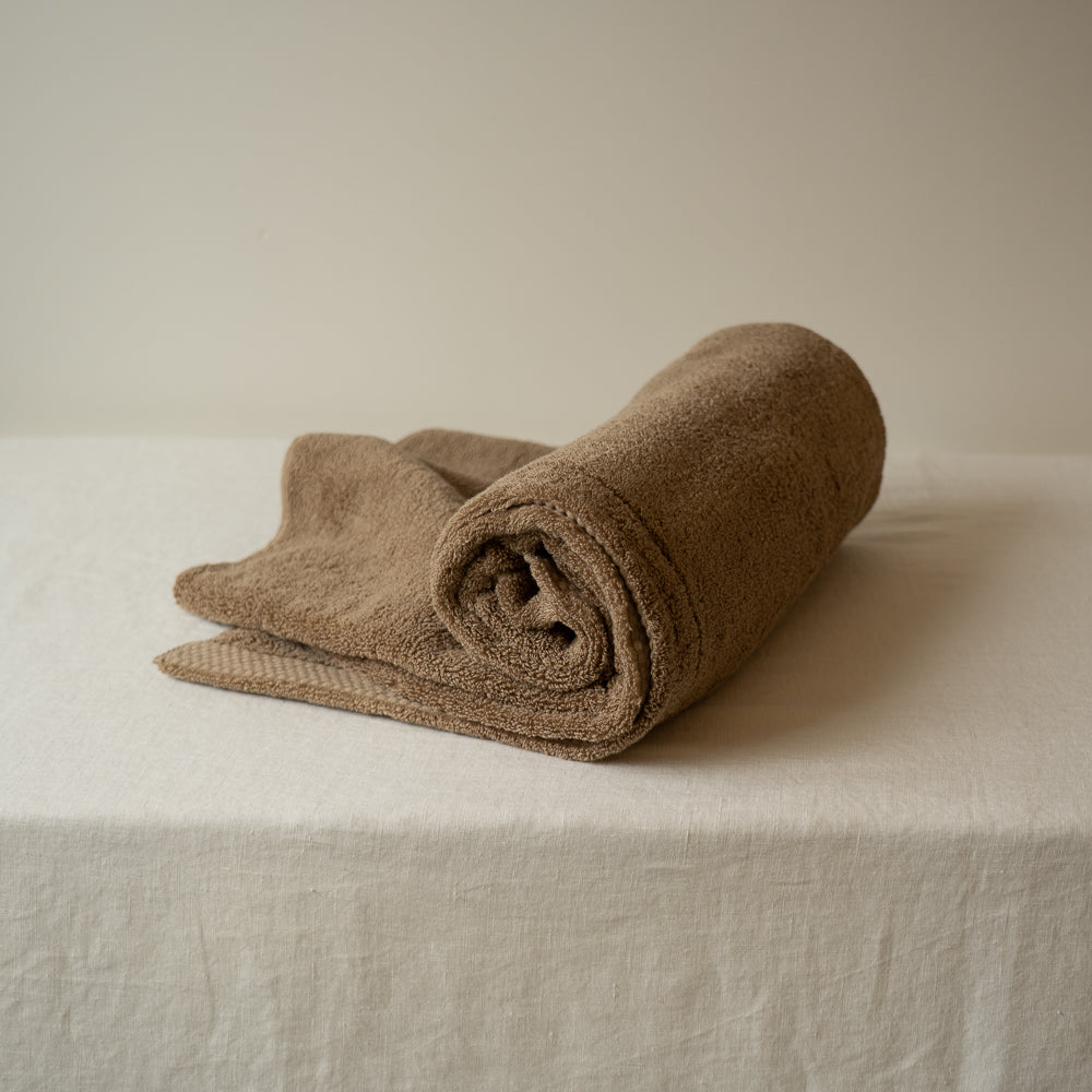 Serviette de bain en coton grand format, brun moyen, roulée