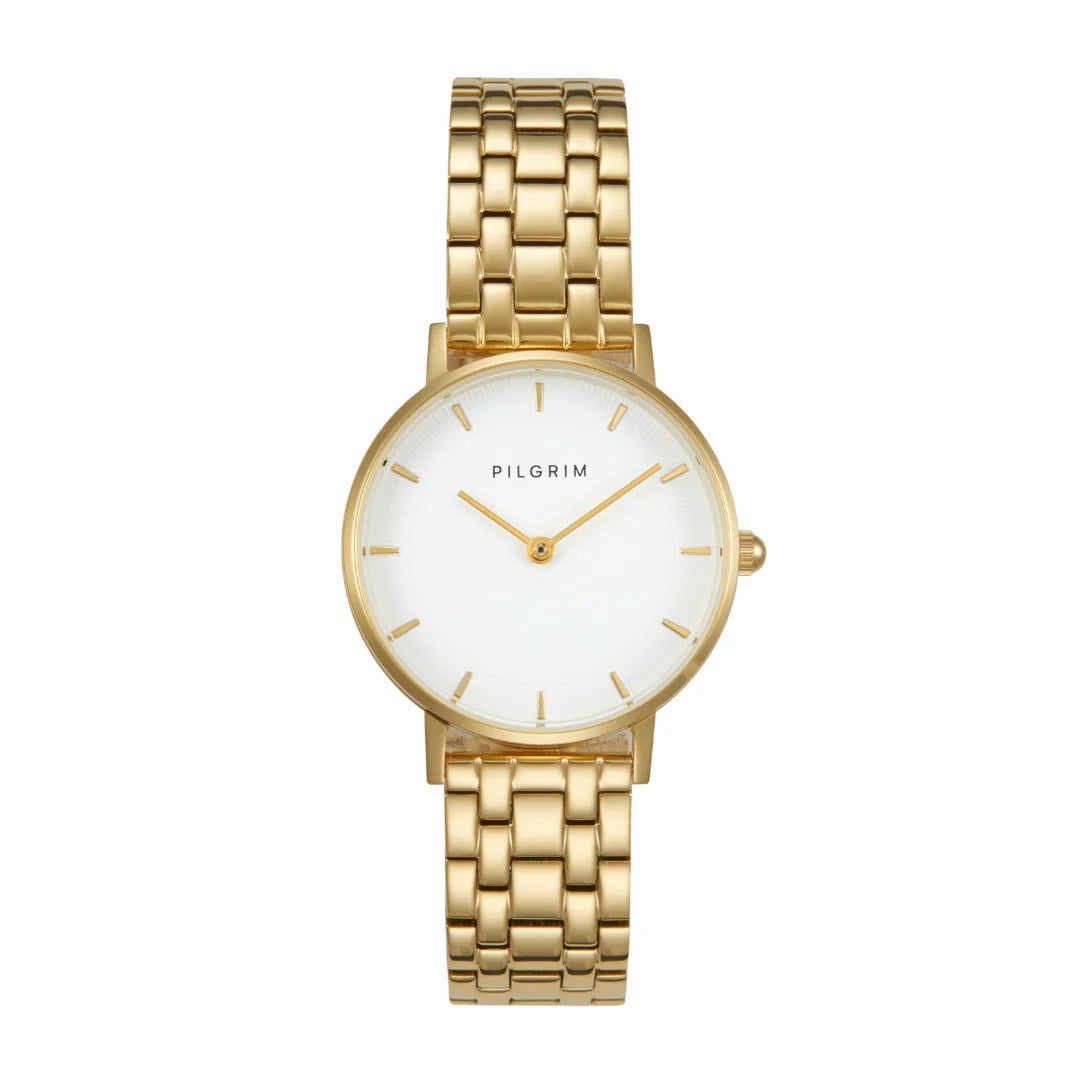Montre TRAVELER CIDER Pilgrim dorée avec cadran blanc minimaliste et bracelet réglable en acier inoxydable.
