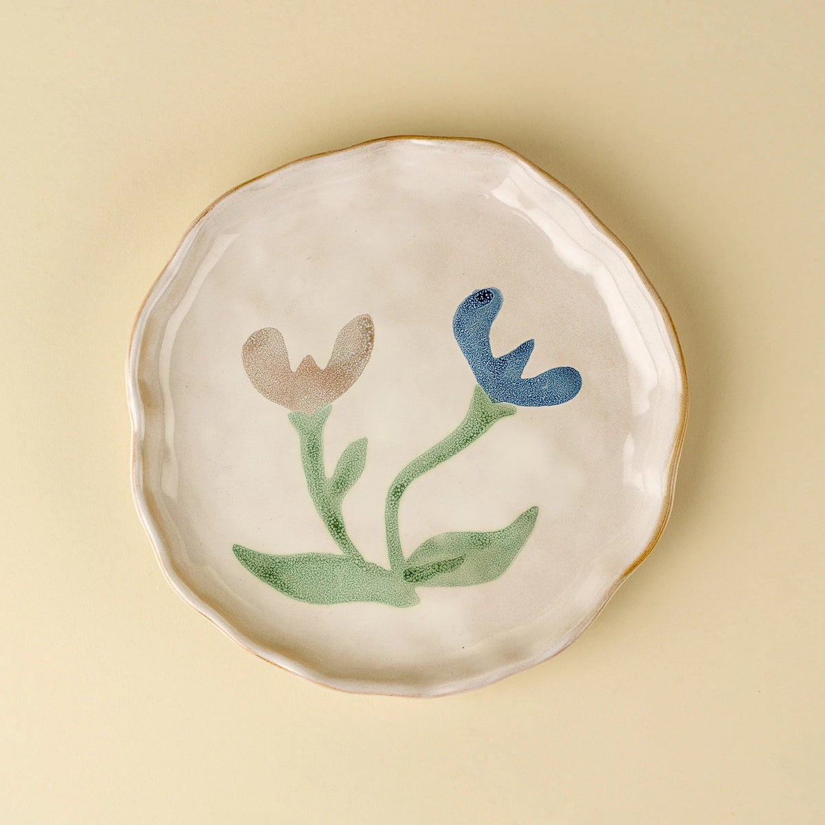 Assiette en céramique blanche à bords en pétales, décor floral bleu et vert