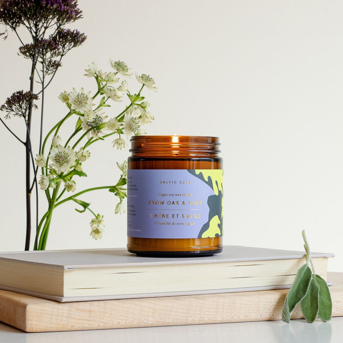 Bougie en pot ambre avec couvercle, étiquette violette et verte chêne & sauge.