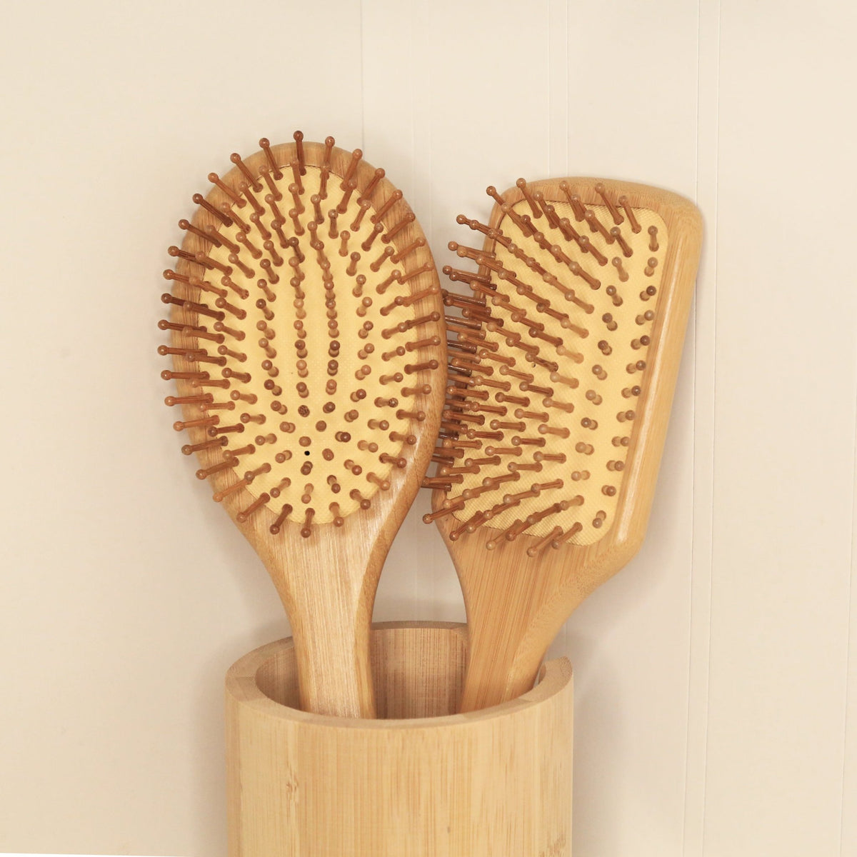 Brosses à cheveux en bambou à picots bruns, posées dans un support