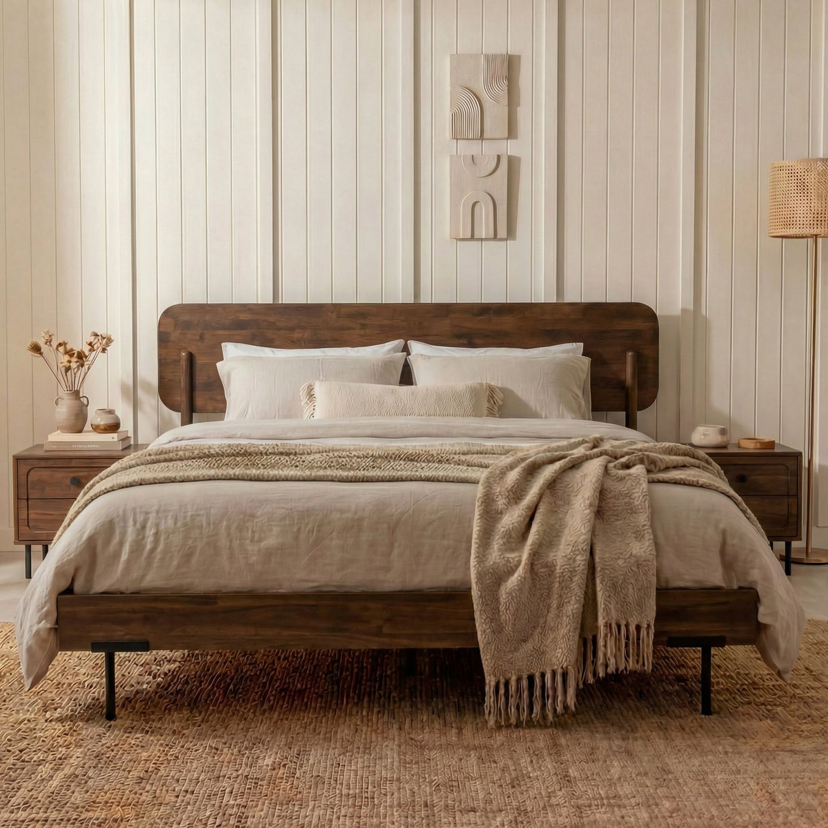 Cadre de lit en bois foncé avec dossier arrondi, linge blanc et couverture beige
