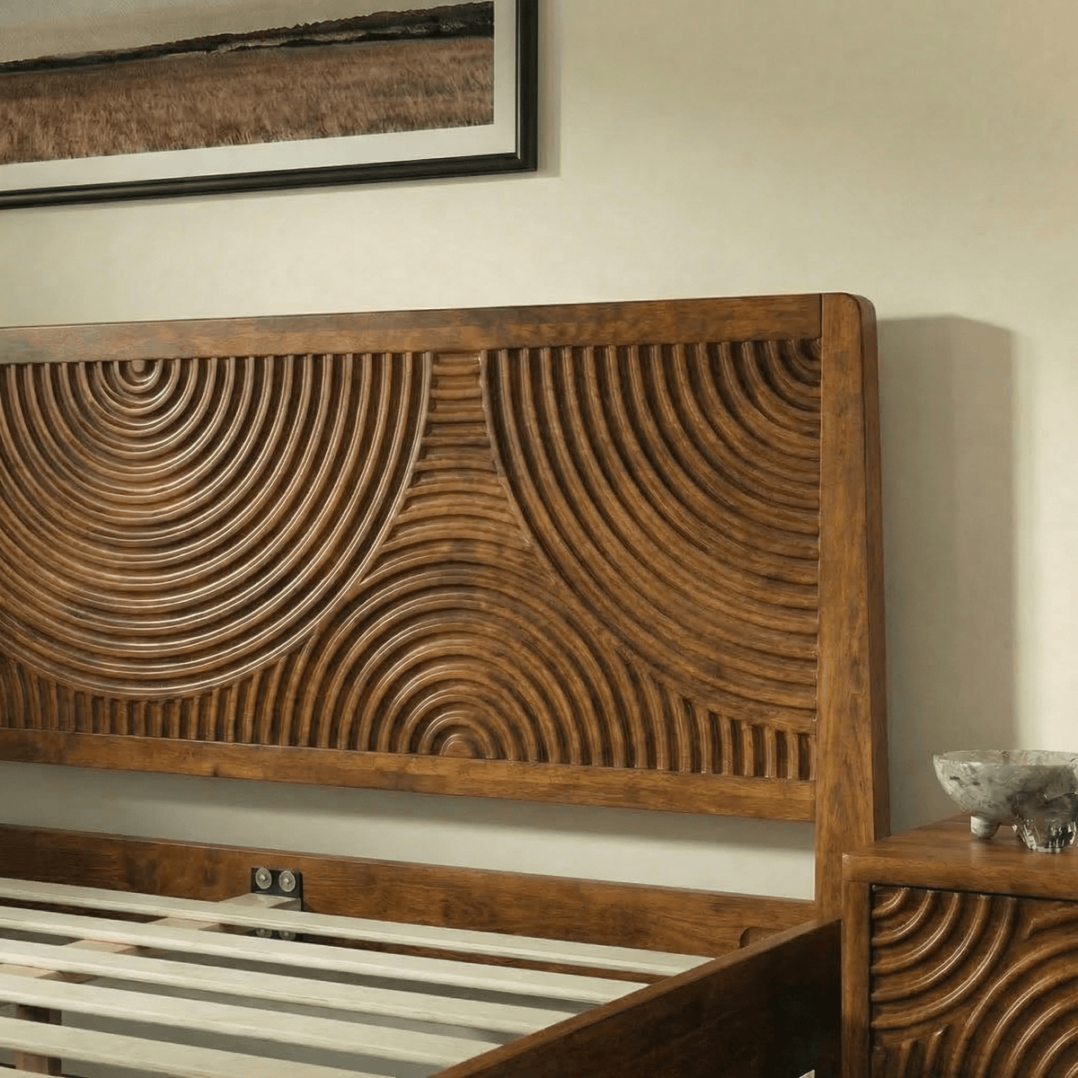 Tête de lit en bois sculptée à motifs courbes, finition noyer, vue rapprochée.
