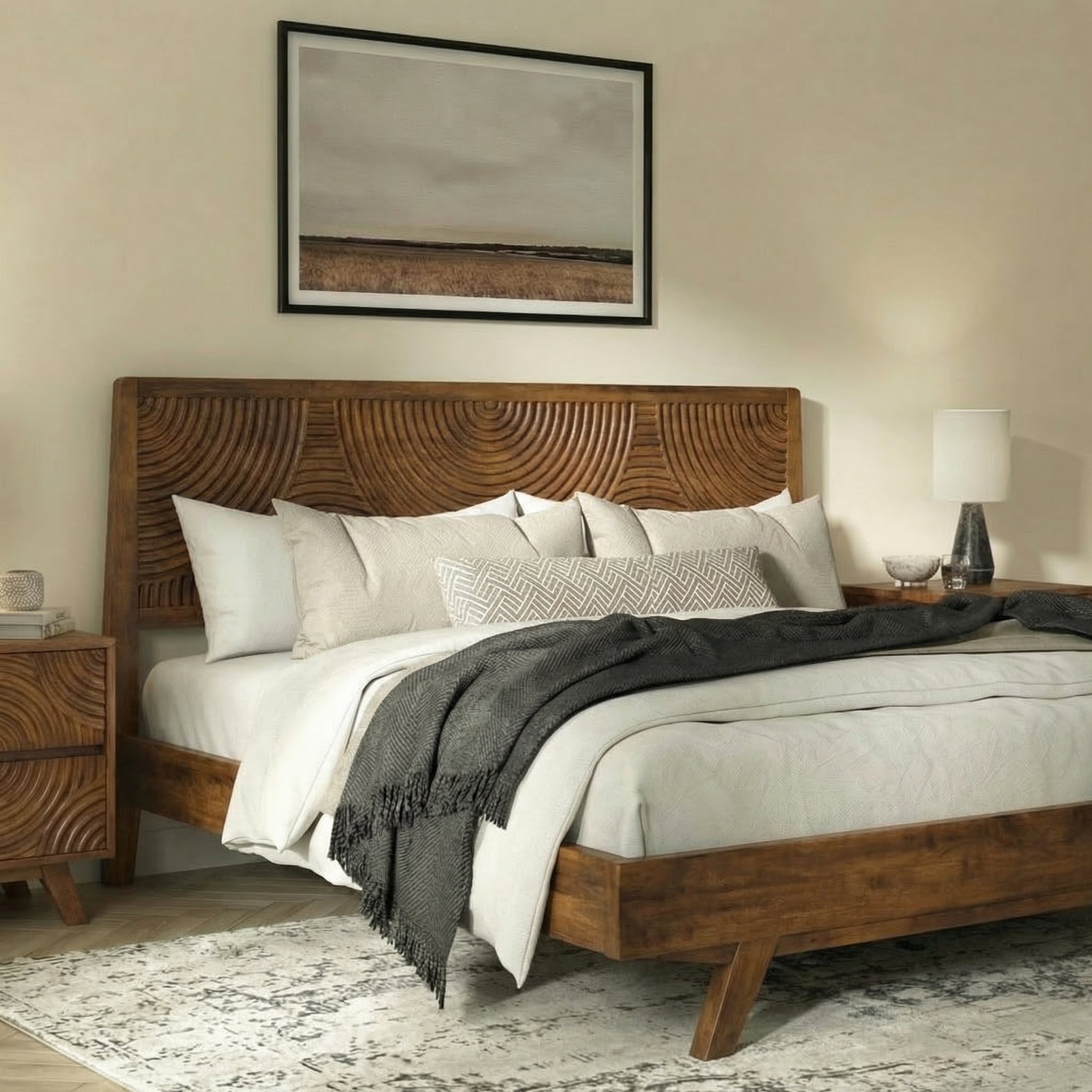 Cadre de lit en bois noyer avec tête de lit sculptée, draps et plaid gris.