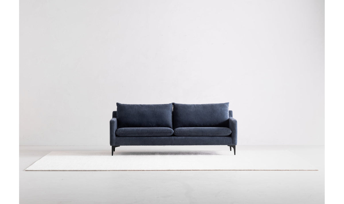 Canapé bleu en tissu, deux coussins de dossier, pieds noirs, vue de face.