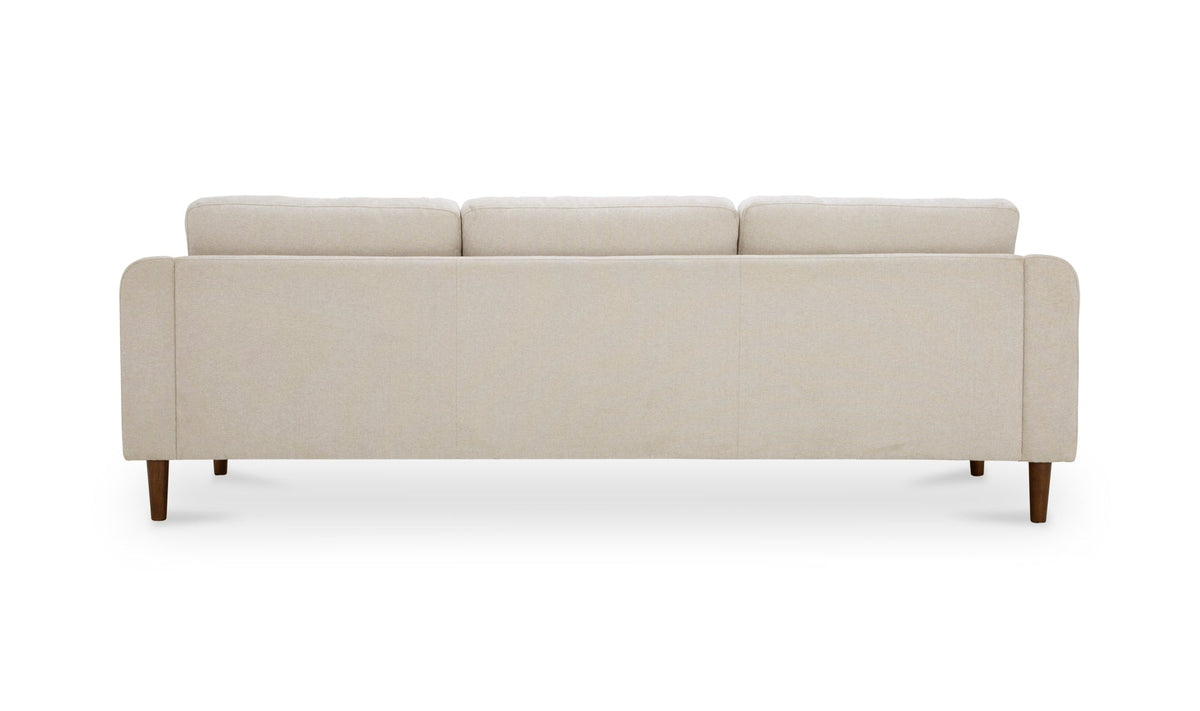 Canapé sectionnel réversible en tissu beige clair, pieds en bois, dossier et assise