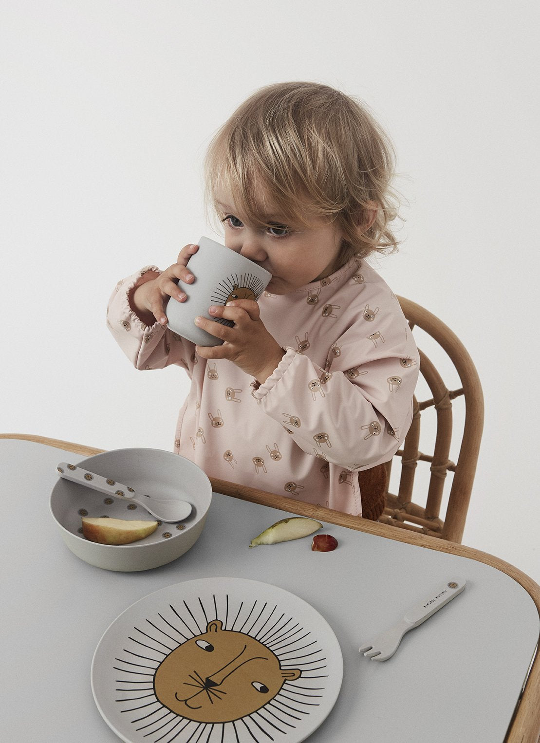 Chaise enfant en rotin naturel avec assise grise, enfant en train de manger