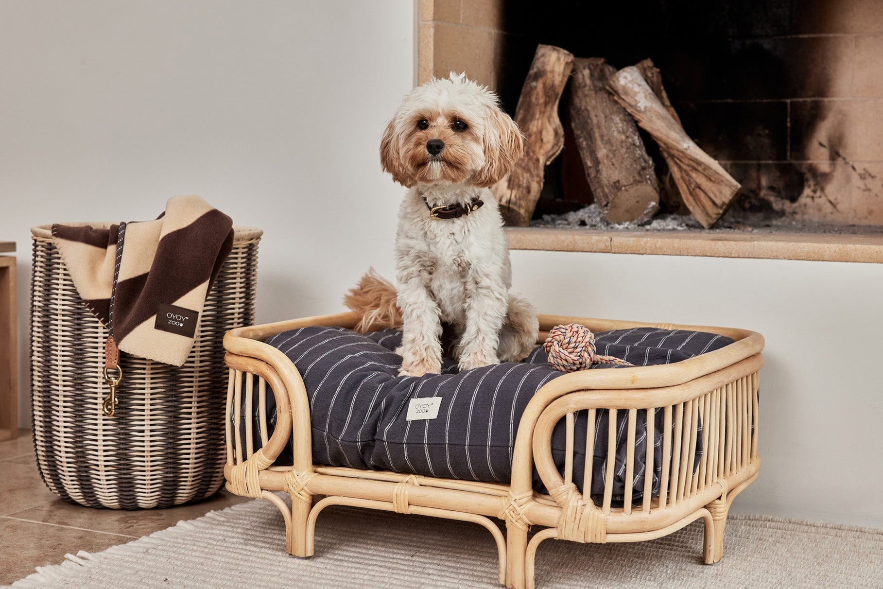 Coussin pour chien anthracite à rayures verticales sur fauteuil en osier