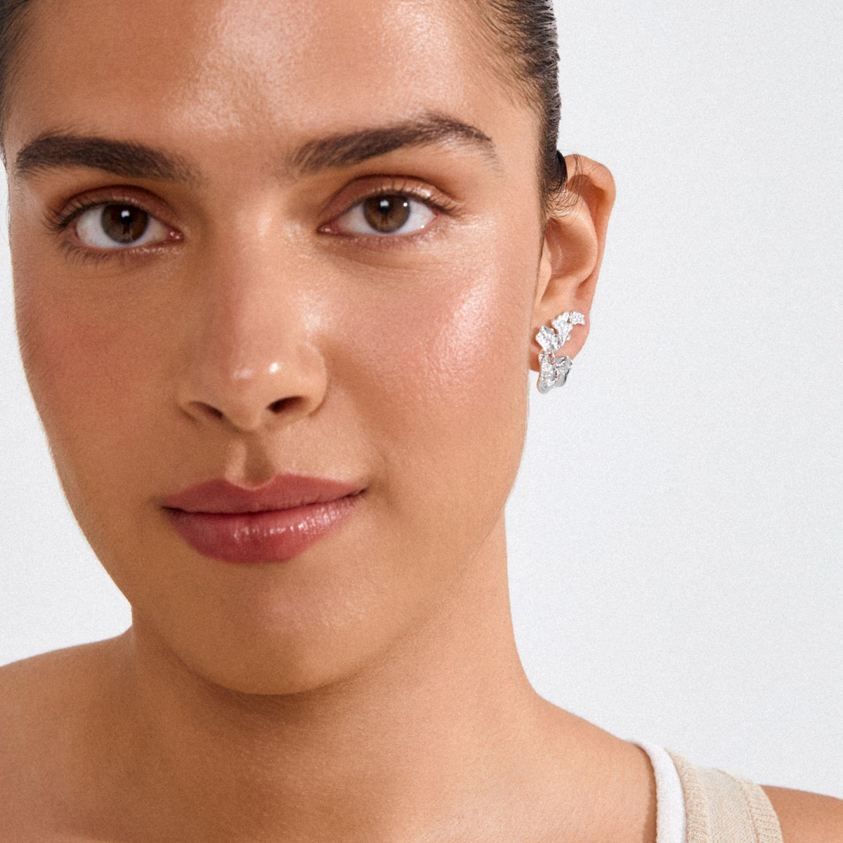 Boucles d’oreilles HORIZON 3-en-1 en cristaux, finition argentée, portées sur l’oreille.