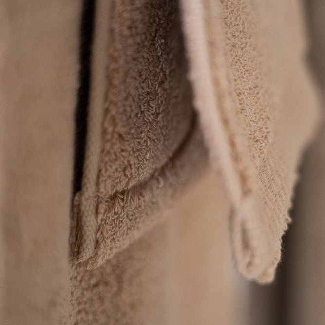 Serviettes en coton beige et brun, détail des plis et du tissu éponge