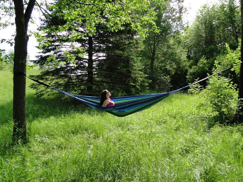 Hamac simple de style brésilien en coton suspendu dans un jardin, idéal pour une personne.