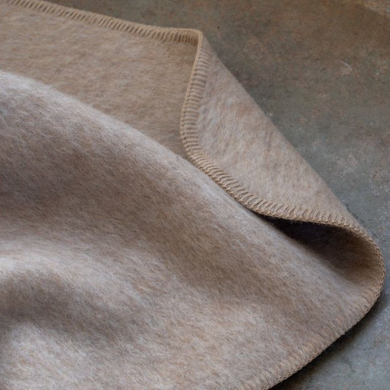 Jeté en laine gris clair, coin et bord à surpiqûre, texture feutrée