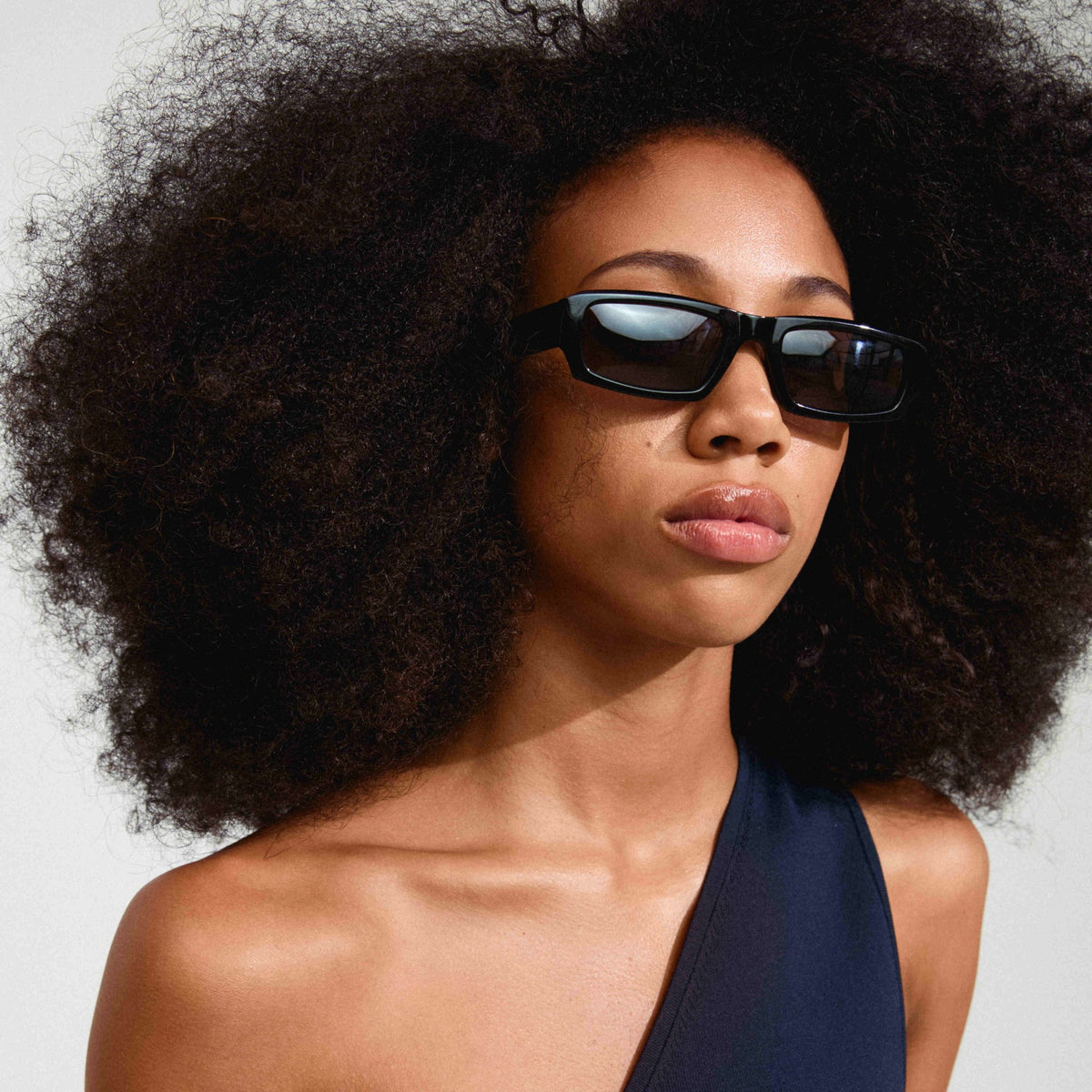 Lunettes de soleil ALAYNA noires, monture carrée et verres teintés.