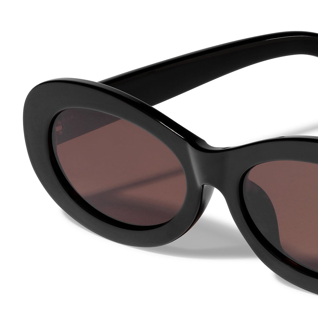 Lunettes de soleil ovales rétro noires Pilgrim, gros monture et verres fumés.