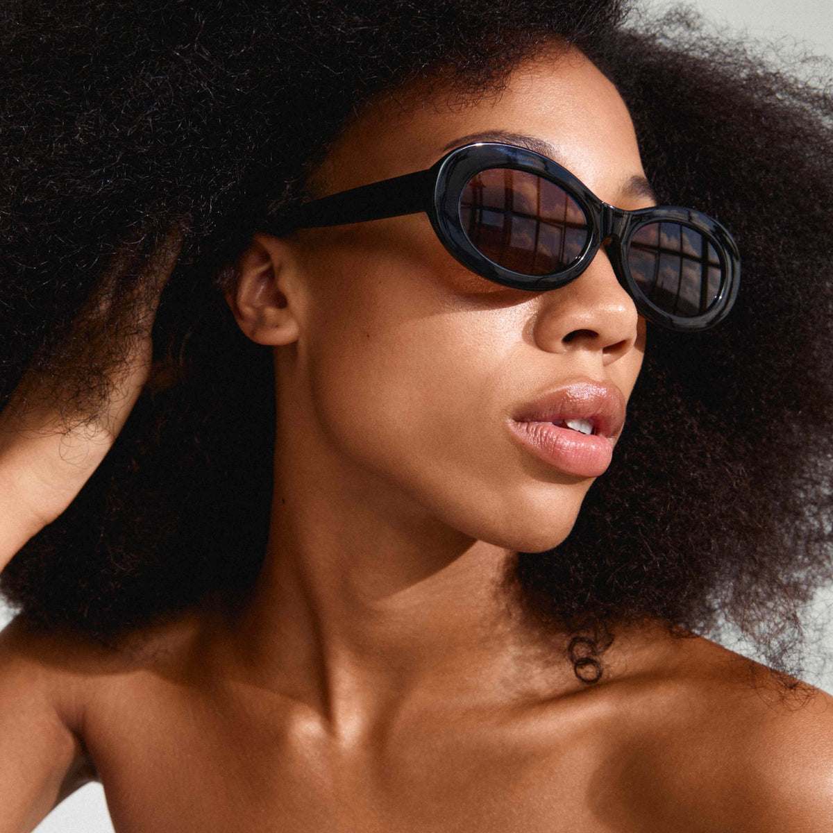Lunettes de soleil ovales rétro noires Pilgrim, verres foncés, vue de côté.