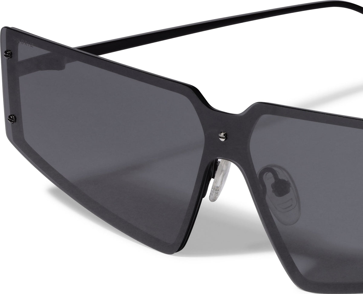 Lunettes de soleil noires, gros verres fumés et monture angulaire brillante.