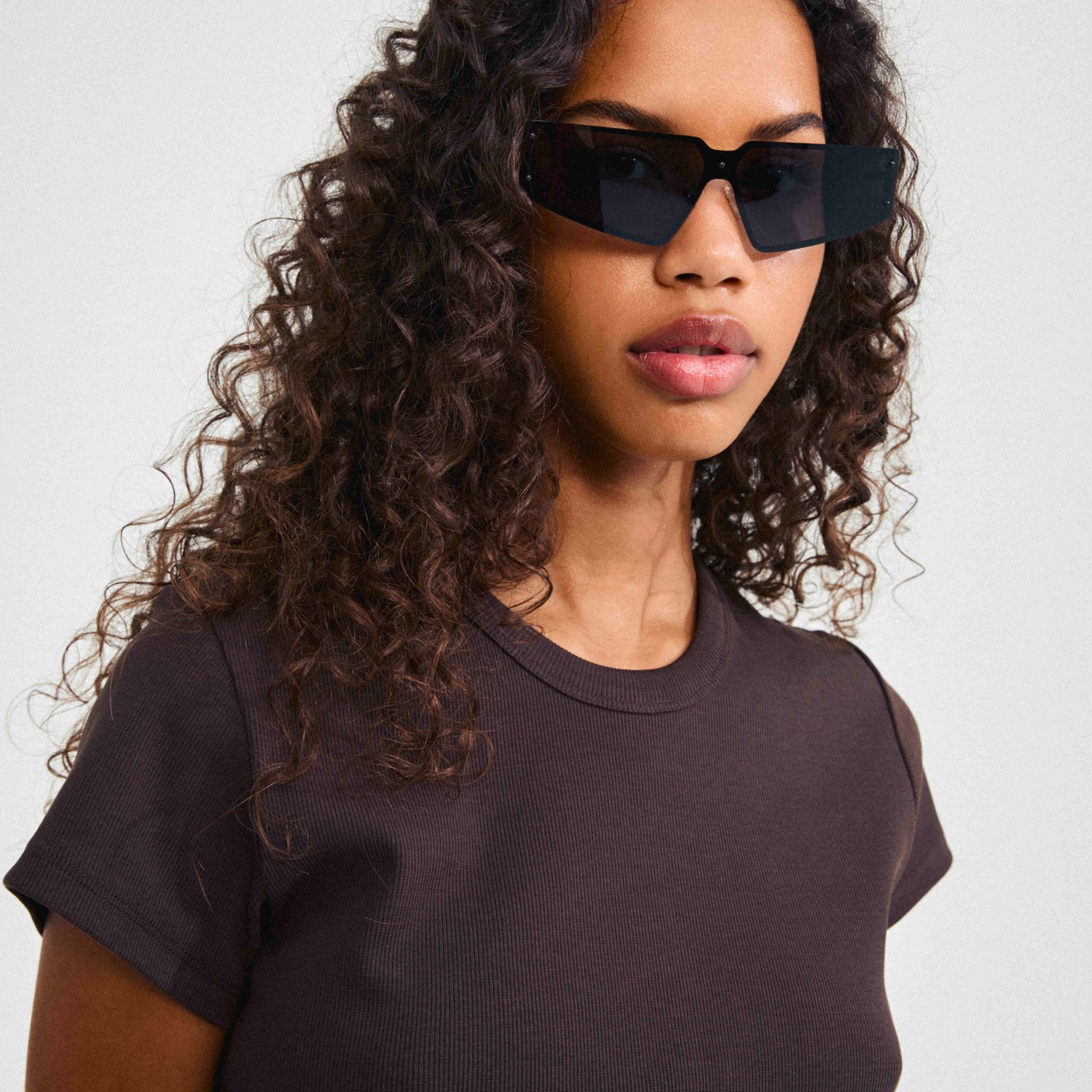 Lunettes de soleil Pilgrim noires à monture métallique angulaire, verres foncés.