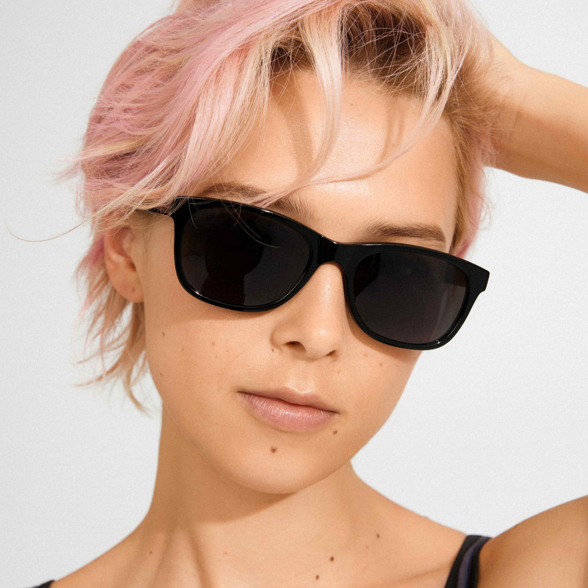 Lunettes de soleil à monture noire avec verres fumés, vue de face sur le visage