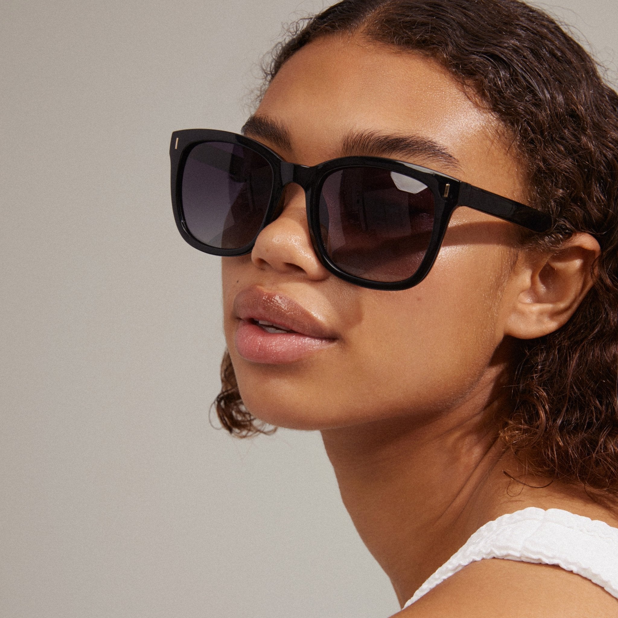 Lunettes de soleil KATYA noires avec verres teintés, portées de profil, style rétro