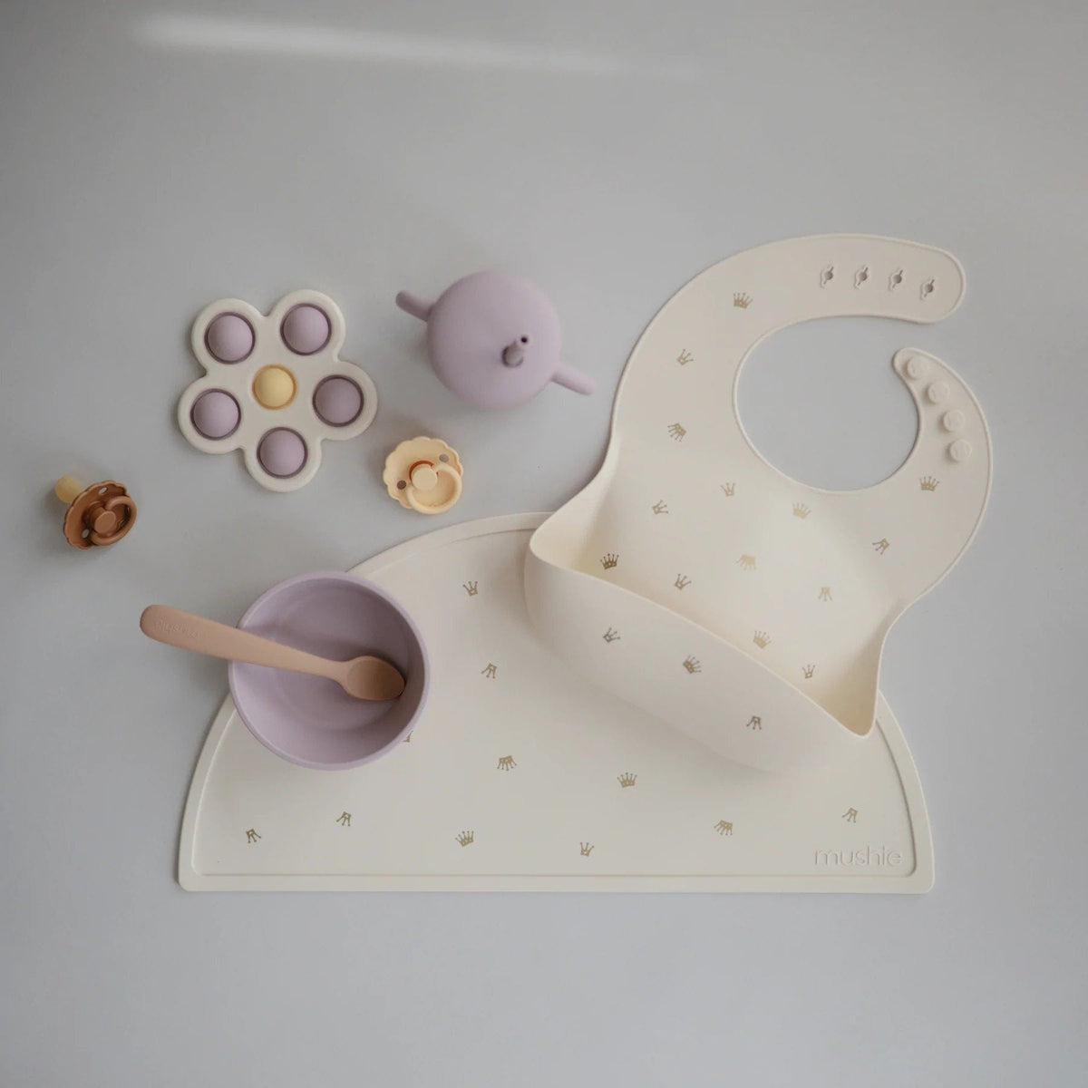 Napron de table en silicone beige, forme bavoir, motifs discrets et ouverture centrale