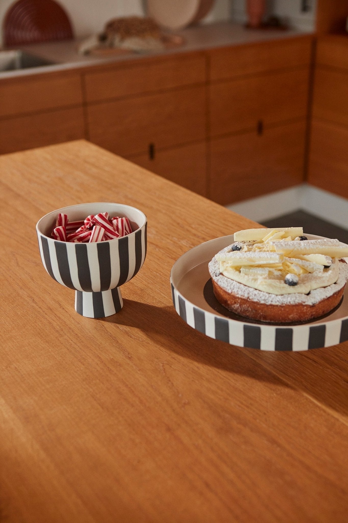 Plateau décoratif en céramique à rayures noir et blanc, deux coupelles sur table.