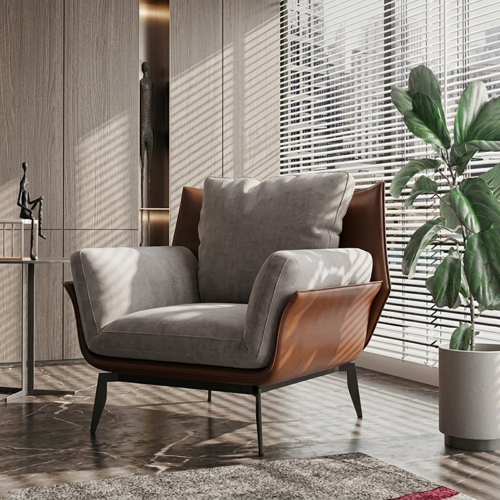 Fauteuil d’appoint gris en tissu, accoudoirs marron en cuir, pieds métalliques noirs.