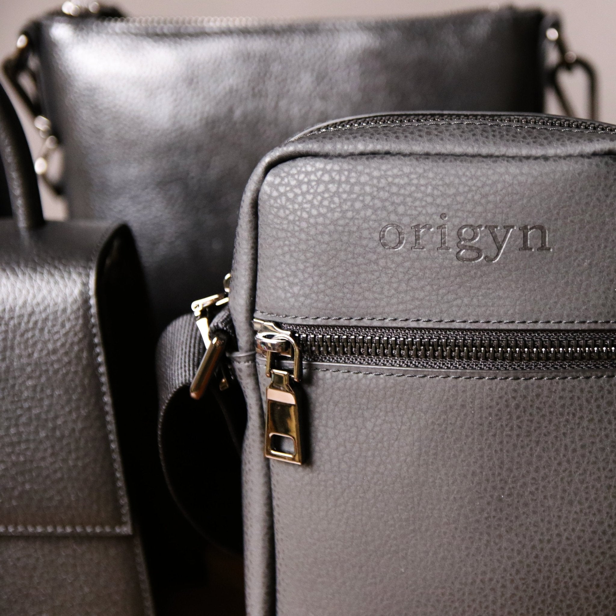 Sac bandoulière noir: cuir texturé, fermeture éclair et logo Origyn sur le devant