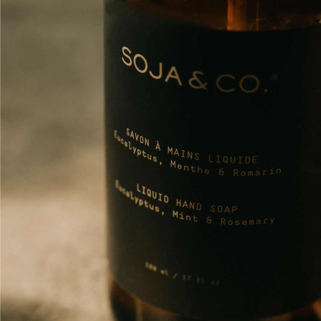 Flacon ambré de savon à mains liquide SOJA&CO, étiquette lisible mais floue